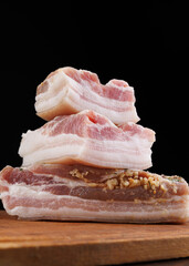 Appetizing salty lard with layers of meat with garlic and herbs. Delicious lard on a wooden cutting...
