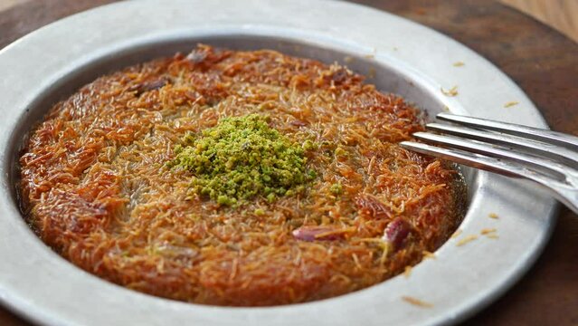 Turkish dessert kunefe with pistachio powder and cheese.