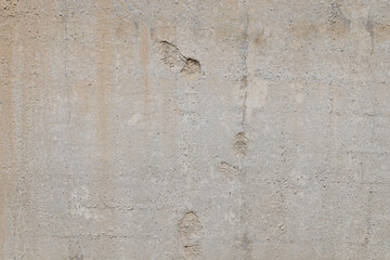 flat gray solid concrete wall with shoe soles imprints, full frame background and texture.