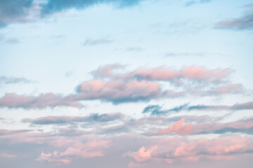 A beautiful sky tinted by the sun leaving vibrant shades of gold, pink, blue and multicolored. Clouds in the twilight evening and morning sky. Cloudy sky background in the evening and during the day.