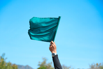 Hand hold green flag for go on doing some activty in playing sport