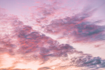 A beautiful sky tinted by the sun leaving vibrant shades of gold, pink, blue and multicolored. Clouds in the twilight evening and morning sky. Cloudy sky background in the evening and during the day.