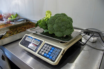 weighing broccoli at work with an electronic scale