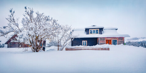 Christmas postcard. Snowy morning scene of old vooden house on Kryvopilʹsʹkyy pass. Panoramic...