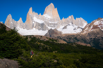 Fototapeta na wymiar A woman trekking to Campamento Poincenot with Mt.Fitz roy as background and clear sky (Argentina, Patagonia, El chalten)