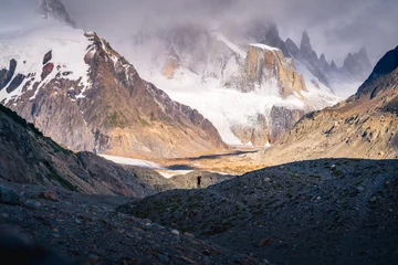 Tableaux ronds sur aluminium Cerro Torre A tiny woman standing alone in the Agostini campsite surrounded by mountain range in the morning with Mt.Cerro torre as background (Patagonia)