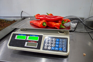 weighing red pepper at work with an electronic scale