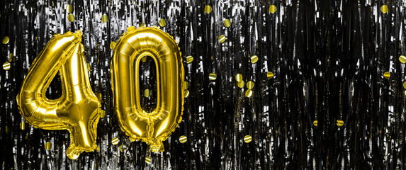 Gold foil balloon number number 40 on a background of black tinsel decoration. Birthday greeting card, inscription forty. Anniversary event. Banner.