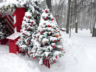 green Christmas trees in the snow with red balls