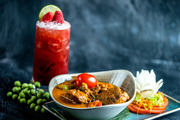 Spicy Indian chicken curry served beautifully with strawberry juice, tomato, and berries.