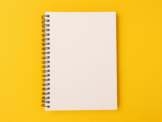 Blank spiral notebook over yellow background flat lay 
