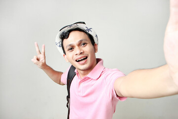 Asian man backpacker taking selfie photos. digital nomad and travelling concept. on isolated background