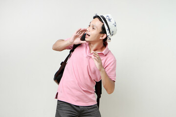 Asian man backpacker shouting outloud. digital nomad and travelling concept. on isolated background