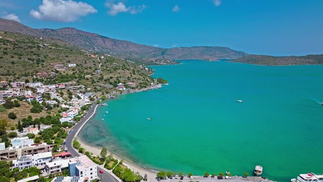 Scenic beach with calm turquoise water on the Island of Crete in Greece in 4K. Greek Paralia Schisma Elountas Compact Beach. Calm waters pedal boat umbrella rentals by Mediterranean Sea