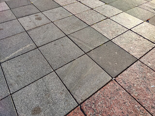 paving stone tiles of square and rectangular shape of gray in perspective. Close up road surface. Abstract Background, texture, frame, place for text, copy space