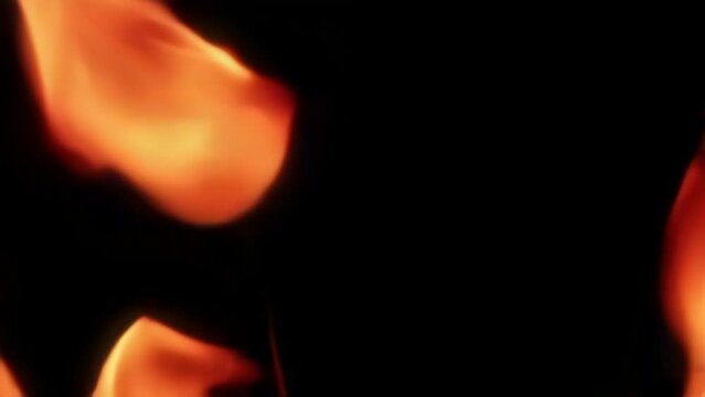 Tongues of bright flame of fire. On a black background. Filmed is slow motion
