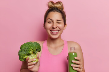 Healthy lifestyle. Studio shot of young fit happy smiling European girl keeping long hair in bun...