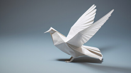 A white paper dove origami on a blank grey background.
