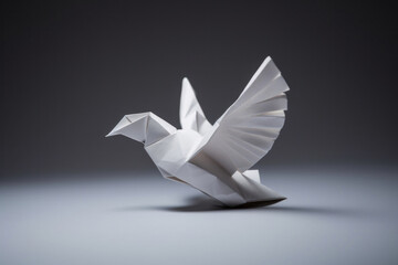 A white paper dove origami on a blank grey background. - obrazy, fototapety, plakaty