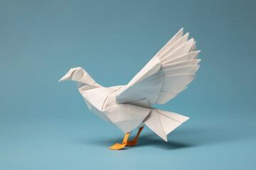 A white paper dove origami on a blank grey background.