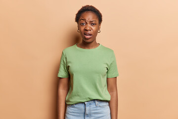People negative emotions concept. Indoor photo of young confused African american girl wearing...