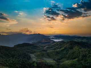 Panorama of sunrise on the mountains, Beautiful landscape with hills and mountains with knee timber and yellow grass and valleys filled with mist lightened with warm sunrise light.