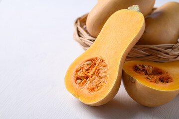 Half butternut squash pumpkin in basket on white background