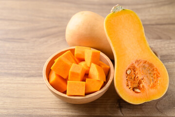Sliced butternut squash pumpkin in a bowl on wooden background