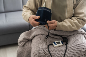 Elderly Man check blood pressure and heart rate at home with digital pressure very high blood...