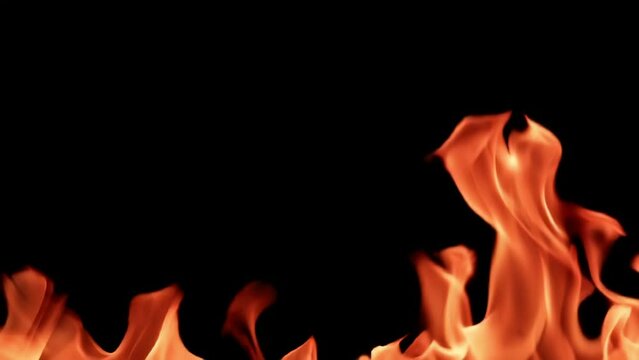 Tongues of bright flame of fire. On a black background. Filmed is slow motion