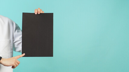 Hand is hold A4 board and point . Wear chef uniform on mint green or Tiffany Blue background..