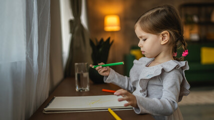 Toddler girl caucasian child play with crayons at home