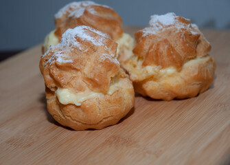Princess donuts with powdered sugar on a wooden table. Flat lay. Food concept.