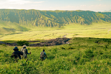 A group of hikers against mountains and valleys at Mount Ol Doinyo Lengai in Tanzania