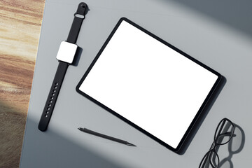 Top view of empty white tablet screen, digital watch, pen and glasses on wooden tablet. Devices at...