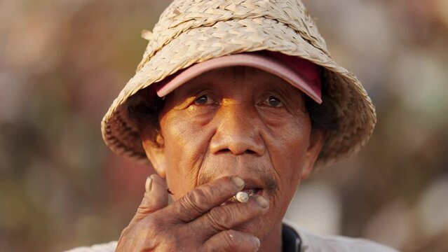 Portrait of elderly asian man smoking cigarette in southeast asia