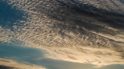 Coucher de soleil, sous un ciel voilé et pommelé, par des nuages de haute altitude