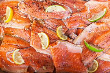 Red fish fillet pieces with lemon and lime pieces on top.