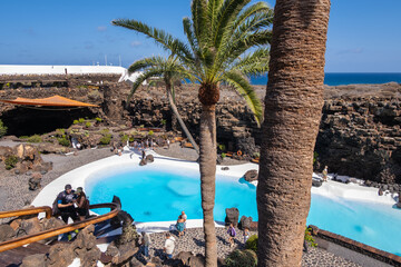 Pool of blue waters and palemeeras, outside the cave of Los Jameos del Agua. Light at the end of...