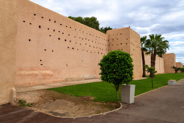 Photo of the city walls of Marrakech. Walls with holes for pigeon nests. Cloudy day.