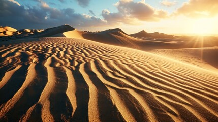 Textured sand dunes with ripples and shadows under a sunset sky.