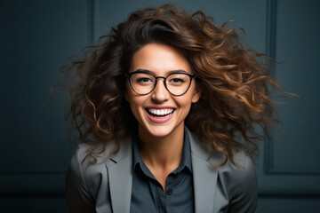Woman with glasses smiling and wearing suit and black shirt.