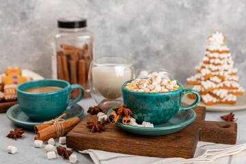 Hot drink with marshmallows and candy cane in cup on texture table.Cozy seasonal holidays.Hot cocoa with gingerbread Christmas cookies.Hot chocolate with marshmallow and spices.Copy space.
