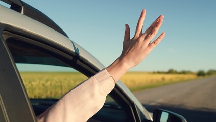 girl rides car with her hand out window, traveling with friends sunny day, hand window smiling teenager sunny weather, happy family concept. man window car, woman waving her hand from window, hand