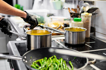 Chef hands cooking cheese sauce in the restaurant kitchen