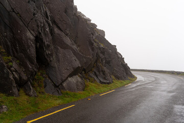 Mysterious road with dark rock and peat on a foggy day on the virgin Irish Atlantic coast