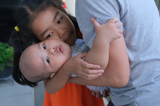 A mother playing with her daughter and baby boy