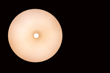 switched on lamp on a black background with space for an inscription