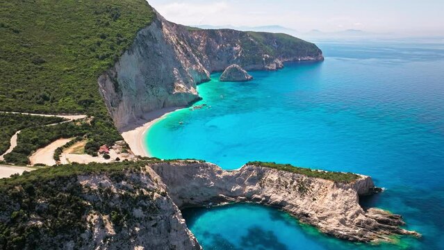 Porto Katsiki beach with turquoise water bordered by concave pale cliffs. Aerial view of crystal clear blue waters with picturesque views on the Ionian island of Lefkada, Greece.