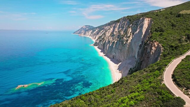 Porto Katsiki beach with turquoise water bordered by concave pale cliffs. Aerial view of crystal clear blue waters with picturesque views on the Ionian island of Lefkada, Greece.